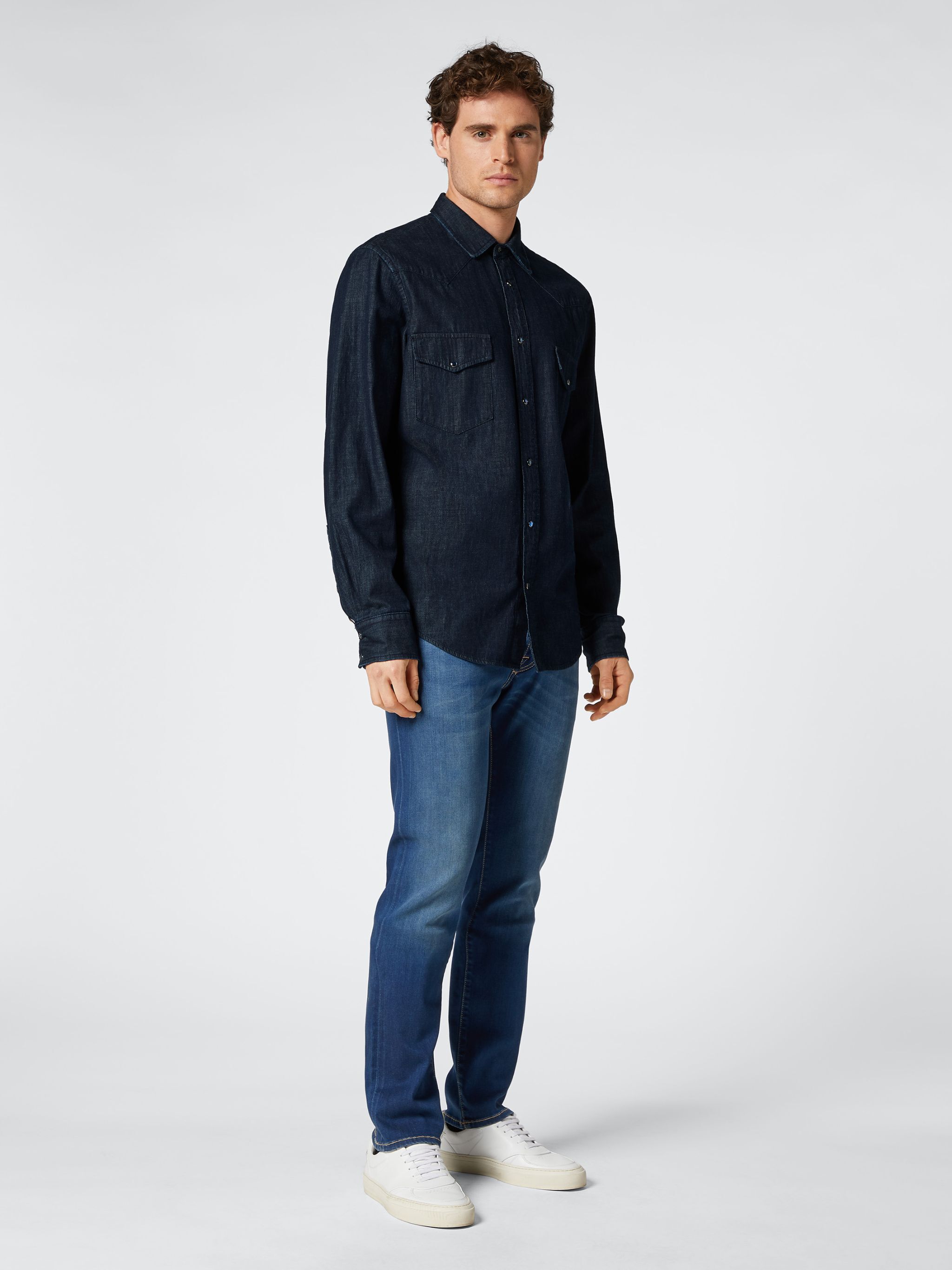 Desk with leather desk pad, walnut desk organizer, wireless keyboard and mouse, and porcelain mug.