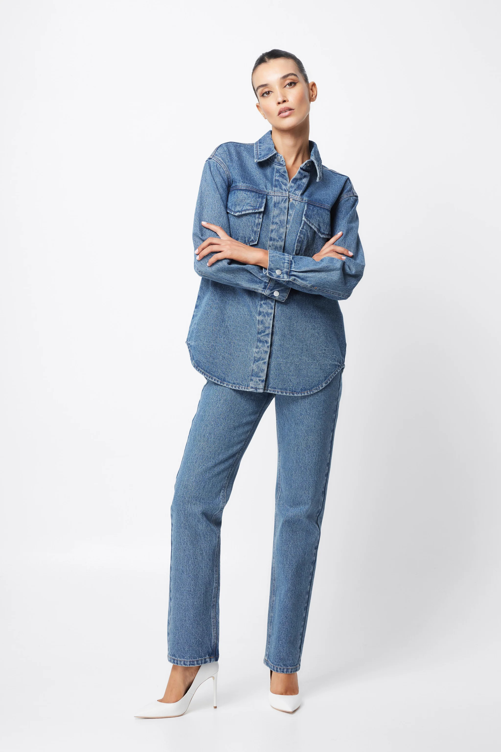 Wood table with porcelain mug, leather journal, brass pen, leather key ring, and a houseplant.